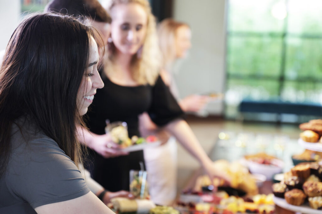 Image of woman smiling and getting food from 飞艇官方体彩网+开奖查询记录结果-幸运飞行艇168结果号码记录查询 table