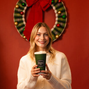 Image of smiling woman holding coffee cup