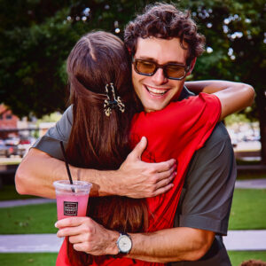 Image of man huggin woman holding drink