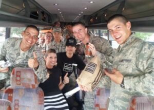 Image of Corner Bakery team members with soldiers on a bus